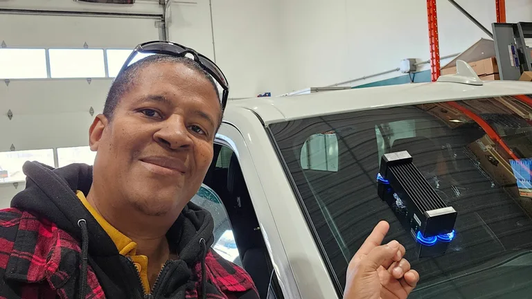 Technician beside a windshield with a repair tool attached