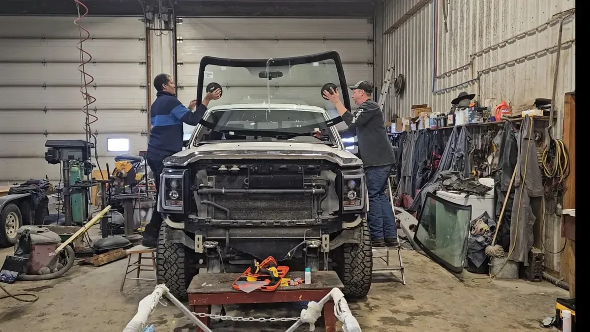 Technicians installing a windshield in a glass shop