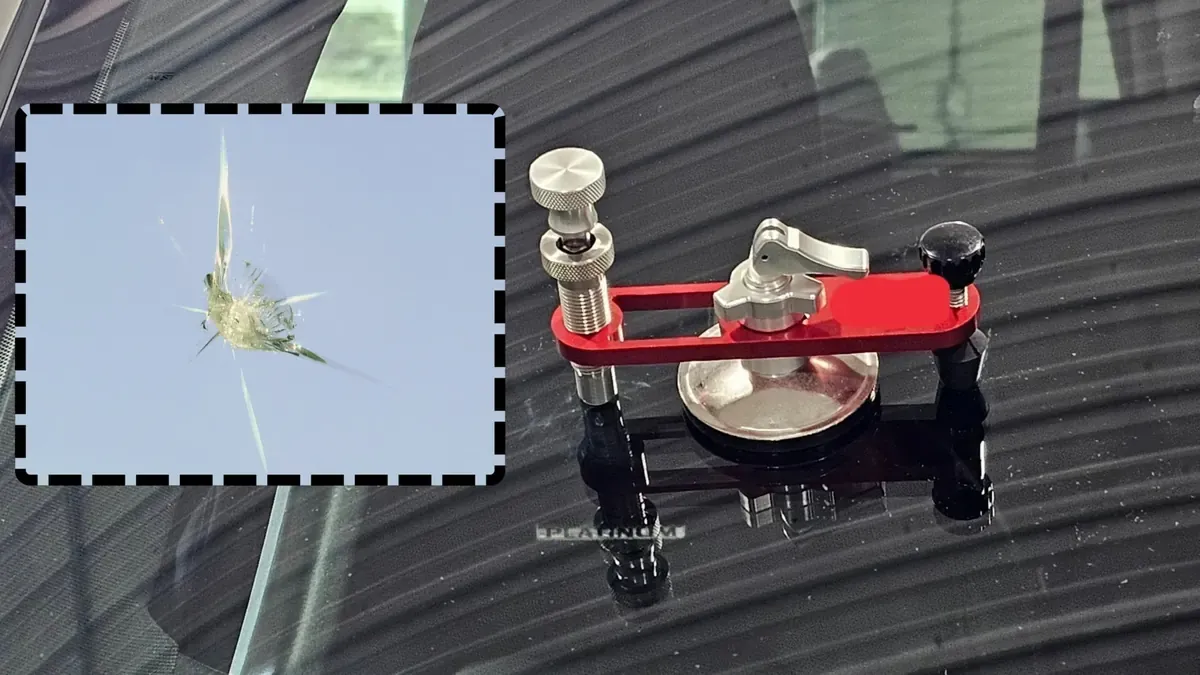 Windshield chip repair tool injecting resin into a stone chip